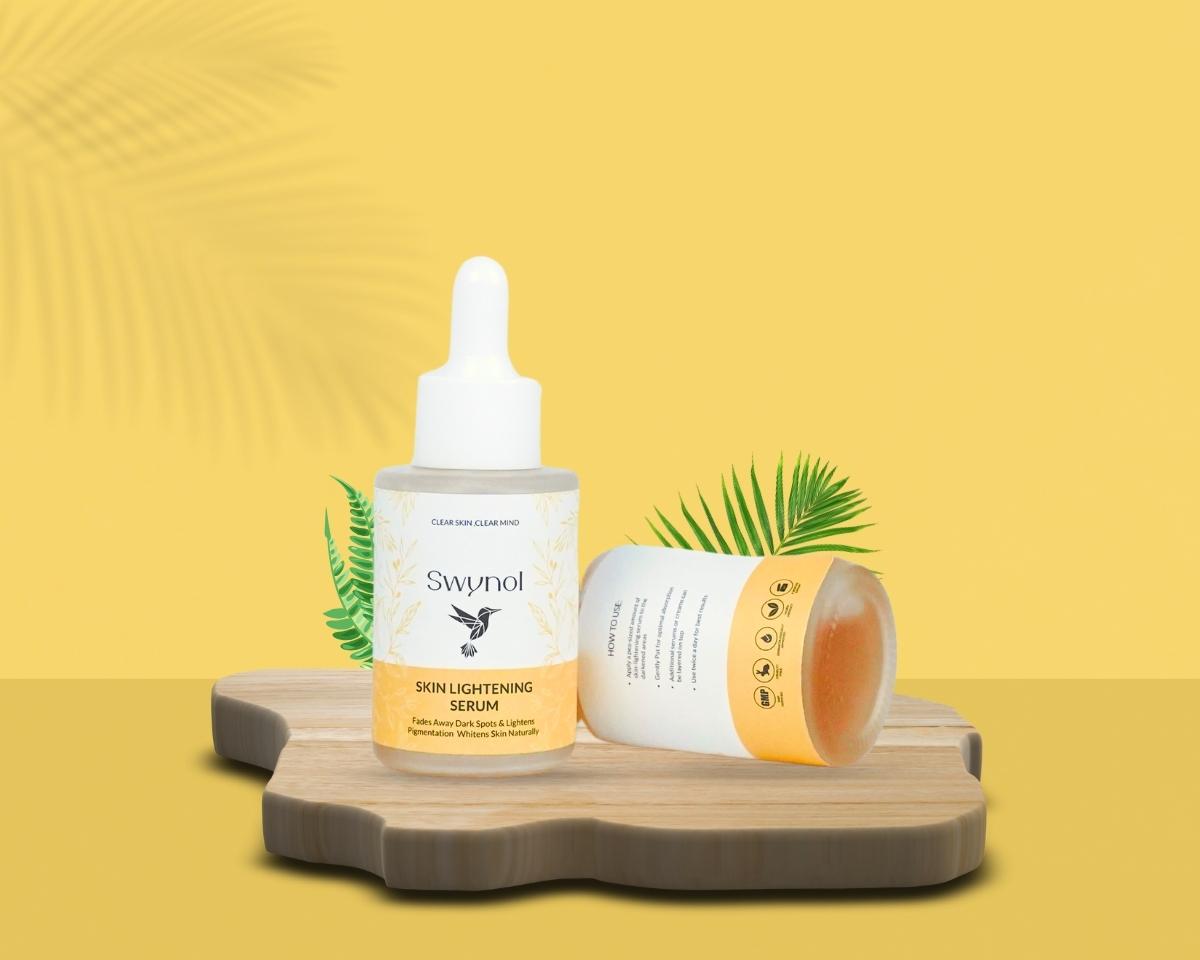 Swynol Skin Lightening Serum with Mulberry Extract placed on a wooden board, styled with palm leaves and a product jar on a soft yellow background. formulated to address skin concerns like hyperpigmentation and dullness.